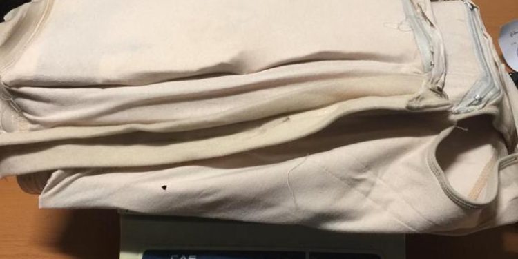 DETIENEN EN EL AILA MUJER INTENTÓ LLEVAR A NY CHALECO RELLENO PRESUMIBLEMENTE COCAÍNA.